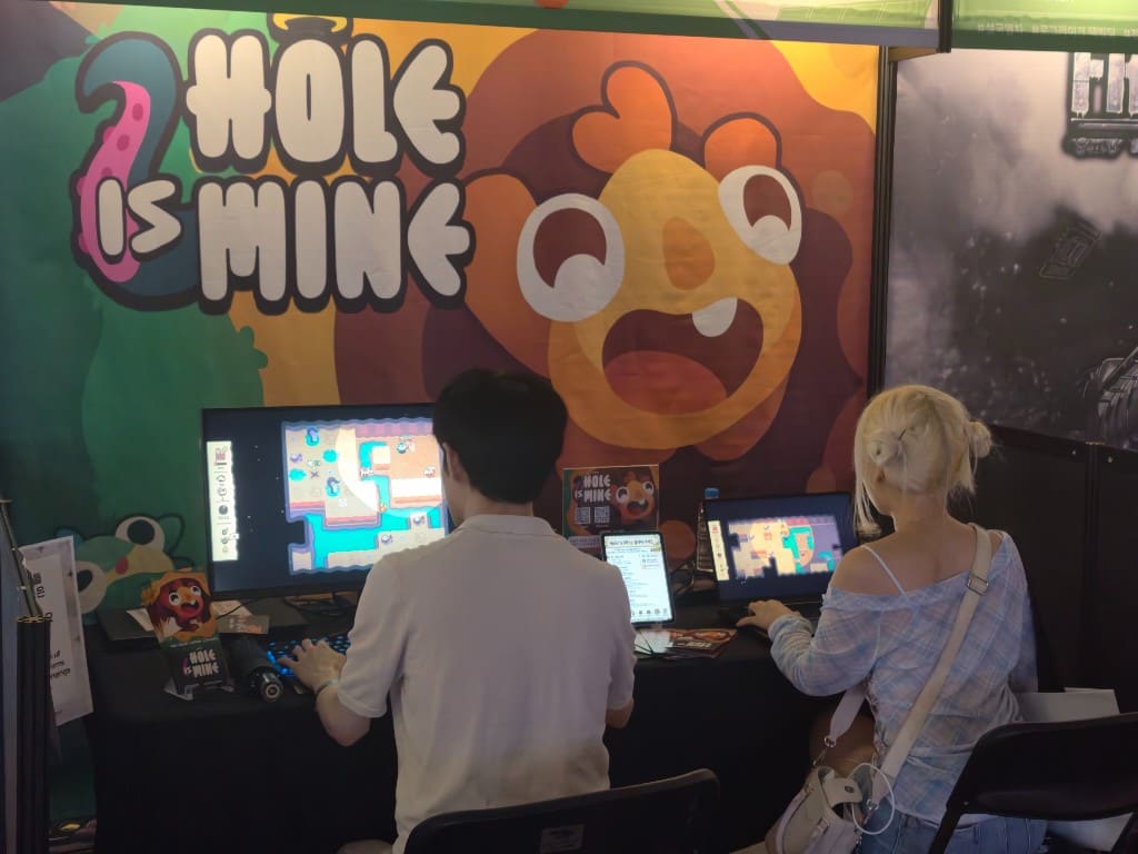 Players trying Hole Is Mine at the BIC 2026 booth